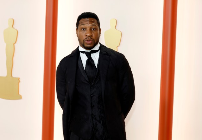 Jonathan Majors at the Academy Awards wearing a black suit