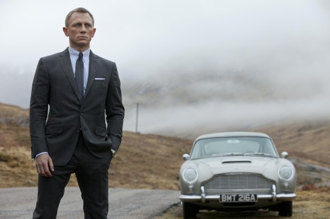 Daniel Craig with car behind him in scene from Skyfall