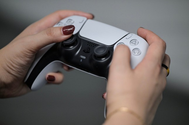 A PlayStation employee demonstrates how to use the PlayStation 5 Pro console, at the Sony headquarters building in central Tokyo on November 27, 2024. December 3, 2024 will mark the 30th anniversary of the first release of Japan's Sony PlayStation, transforming the world of video games. (Photo by Richard A. Brooks / AFP) (Photo by RICHARD A. BROOKS/AFP via Getty Images)