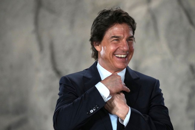 Tom Cruise smiles as he receives a Navy Distinguished Public Service Award from The United States Secretary of the Navy Carlos Del Toro presents at the Longcross South Studios, in Runnymede, Surrey, England, Tuesday, Dec. 17, 2024. (AP Photo/Kin Cheung)