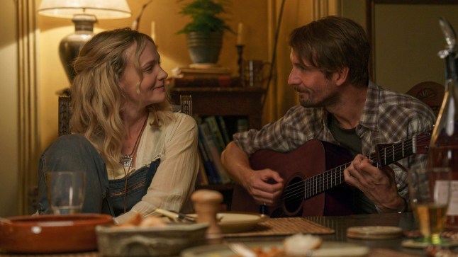 Carey Mulligan, left, and Tom Basden in a scene from The Ballad of Wallis Island. He plays guitar as she looks at him.