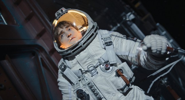 Robert Pattinson as Mickey 1 in the movie Mickey 17, floating around in outer space in a spacesuit.