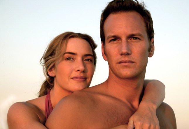Kate Winslet as Sarah embraces Patrick Wilson as Brad over the shoulders from behind, as they gaze into the distance in a scene from Little Children