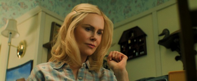 Nicole Kidman as Nancy Vandergroot holds up her fist near her face as she stands in a vintage-style kitchen in the film Holland