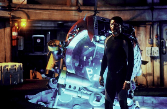 Samuel L Jackson stands in front of an open hatch into water in a wetsuit in Deep Blue Sea