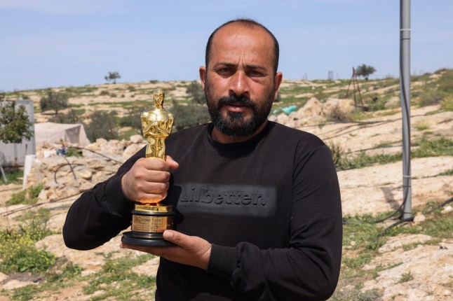 Palestinian filmmaker and Oscar winner for the documentary "No Other Land" Hamdan Ballal poses for a picture with his Oscar, as he recovers after Israeli settlers attacked him at home, in his village of Susya in the south of the occupied West Bank on March 26, 2025.