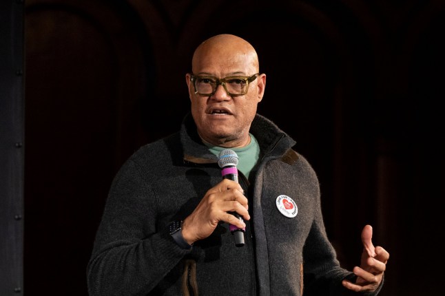 Laurence Fishburne wearing a casual look on stage with a microphone