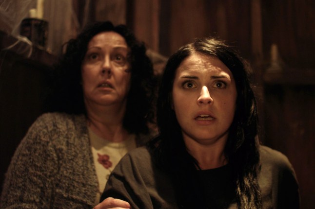 Rima Te Wiata as Miriam and Morgana O'Reilly as Kylie look scared at something in front of them in a scene from Housebound