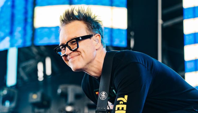 Mark Hoppus of Blink-182 smiles while on stage