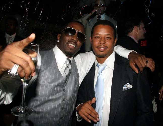 Sean 'P.Diddy' Combs in a grey suit and holding a glass of champagne put his arm around Terrence Howard during the 2006 CFDA Awards