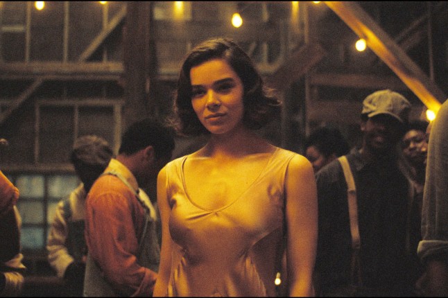 Hailee Steinfeld as Mary in Sinners. She is standing in a crowd of people in the blues bar