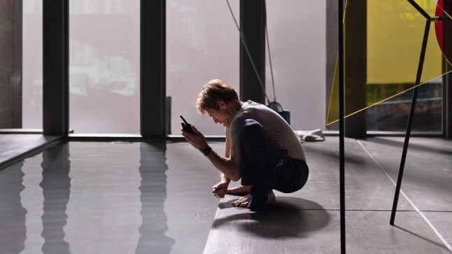 Willem Dafoe as high-end art thief Nemo, crouching by an indoor pool in Inside