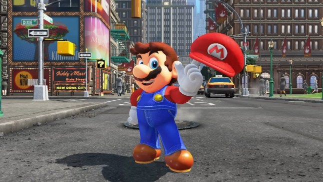 Super Mario Odyssey screenshot, showing Mario in a city street with his red hat perched on his finger.