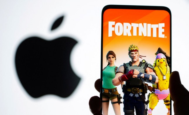 Fortnite game graphic is displayed on a smartphone in front of Apple logo